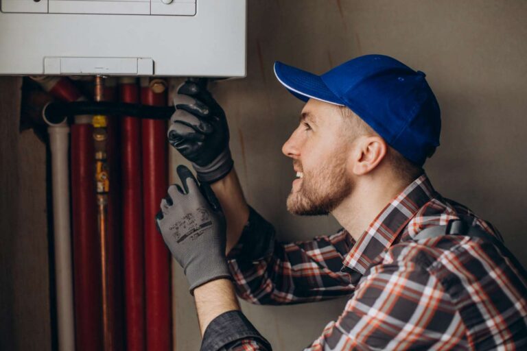 A man is upgrading a condensing boiler. He does the work with gloves on and is visibly pleased with his work.
